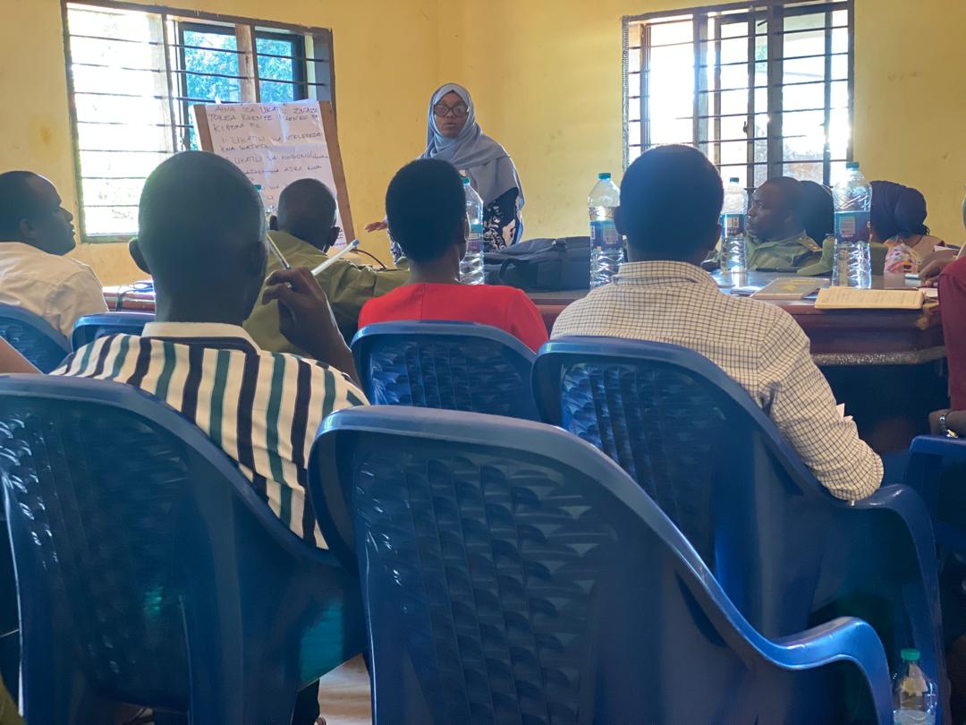 A woman facilitates a community learning session.